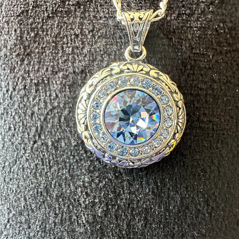 sterling silver round with scroll design and light blue crystal necklace